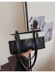 Detail of faux fur and black leather patchwork bag with gold buckle and embossed text