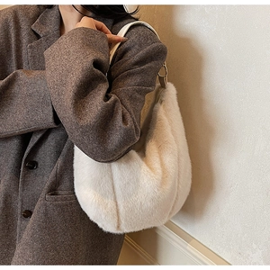 Detail of white faux fur shoulder bag with leather handle and gold metal ring link