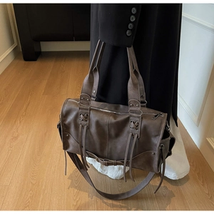 Détails du sac cabas marron foncé avec rivets métalliques et laçage décoratif à pompons