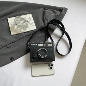 Vintage black camera-shaped crossbody box bag with textured finish and phone size comparison