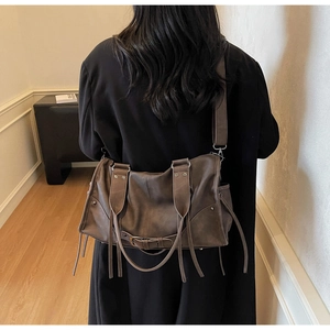 Détail du sac cabas vintage en cuir marron foncé avec longues franges et large bandoulière