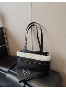 Detail of black faux leather shoulder bag with white plush trim and gold buckle accent
