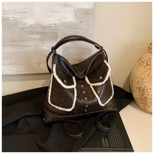 Detail shot of vintage dark brown tote bag with white faux shearling trim and metal studs