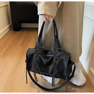 Détail d'un sac Boston vintage noir avec des franges et une texture en similicuir mat
