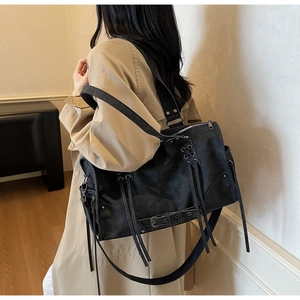 Détail macro du sac cabas utilitaire noir avec œillets métalliques et cuir mat de qualité