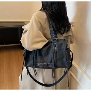 Detail of vintage motorcycle tote bag in matte pleated leather with metallic buckles