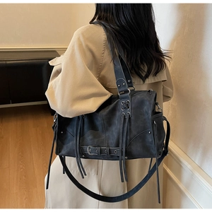 Vue détaillée du modèle portant un grand sac cabas noir style vintage avec des franges