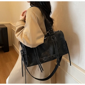 Vue détaillée d'un cabas noir vintage avec boucles de ceinture et glands à franges