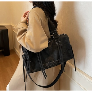 Détail du sac à bandoulière noir mat avec de longues franges et des boucles en cuir