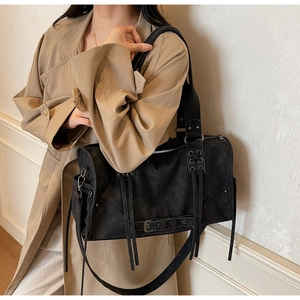 Vue détaillée du sac cabas en daim noir mat avec des franges et des boucles en métal