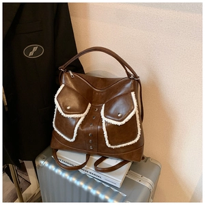 Detail of brown leather backpack with white plush trim and metallic studs on pockets
