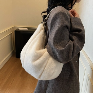 White faux fur cloud tote bag with leather strap and metal ring worn by model