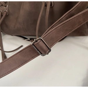 Détail d'un cabas en daim marron café avec bandoulière réglable et boucle en métal