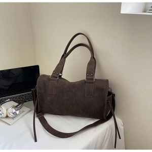 Détail du sac Boston marron vintage en daim avec poignées et finitions argentées