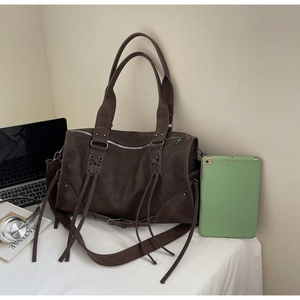 Détail d'un grand sac bandoulière marron vintage avec fermeture éclair à franges