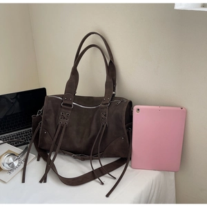 Détail d'un grand sac fourre-tout marron foncé avec fermetures éclair et lanières croisées