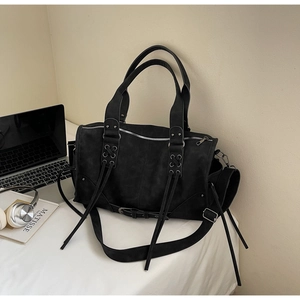 Vue détaillée du sac gothique noir avec des oeillets métalliques et de longues franges