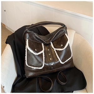 Brown PU leather shoulder bag with white faux fur trim and silver rivets in 45-degree view