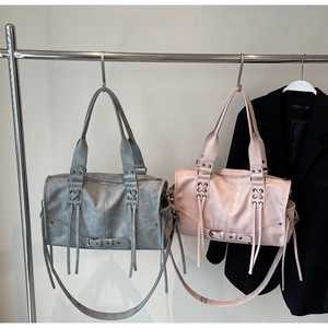 Détail de sacs Boston vintage gris et roses avec fermetures à pompons et bandoulières