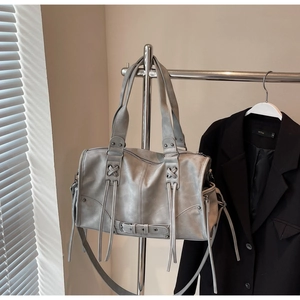 Détail du sac en cuir lavé gris avec des franges et des boucles métalliques