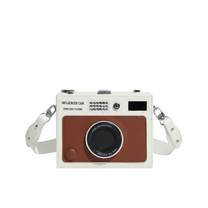 Detail of vintage camera shaped crossbody bag with white leather and brown textured panels