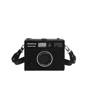 Macro detail of camera-shaped crossbody box bag with pebbled leather and silver metal buckles