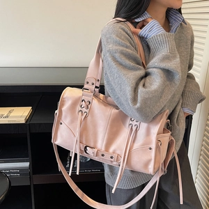 Sac fourre-tout moderne en similicuir rose clair avec œillets et lacets porté par un mannequin