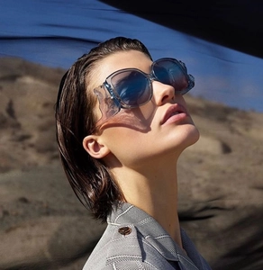 Detail of oversized square sunglasses with gradient blue lenses and side wavy shields