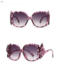 Detail of purple tortoiseshell sunglasses with wave-shaped temples and gradient lenses