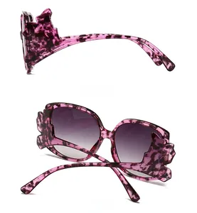 Detail view of purple tortoise shell butterfly frame sunglasses with gradient lenses