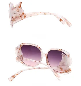 Detail of marble texture frame and wing decoration on purple gradient sunglasses