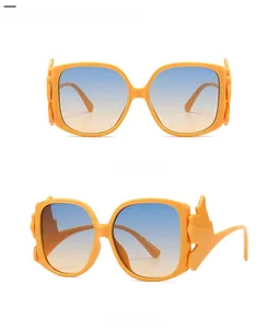 Detail view of orange rectangle sunglasses with blue gradient lenses and wing decor