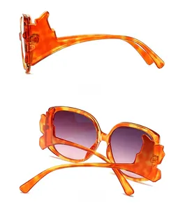 Detailed side and back views of orange tortoiseshell cat-eye sunglasses with purple lenses