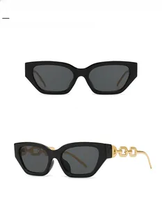 Detail of trendy narrow black square sunglasses with luxury gold chain link temples