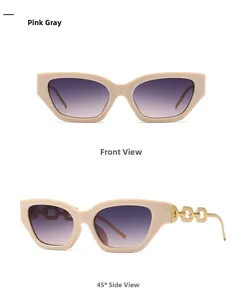 Detail view of cat eye sunglasses with cream frames and gold chain link temples