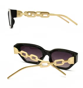 Detail view of cat eye sunglasses featuring thick black frames and bold gold chain temples