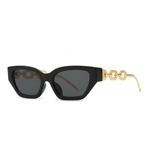 Narrow black cat-eye sunglasses with gold metal chain arms and dark grey lenses