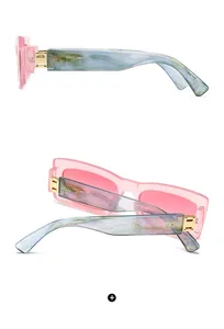 Détail de lunettes rectangulaires avec monture rose et branches larges à effet marbre