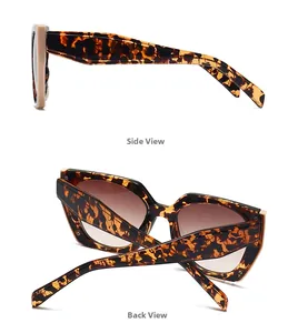 Detail view of large cat-eye sunglasses with tortoise texture and brown gradient lenses