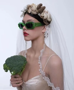 Close-up of trendy green translucent rectangular sunglasses worn by a female model