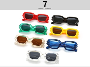 Flat lay of seven rectangular chunky sunglasses with wavy frames in various colors