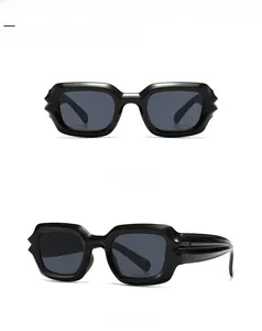 Close-up of modern black square sunglasses with thick frames and wave texture on the side