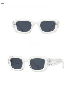 Detail of transparent square sunglasses featuring industrial pyramid hinge ornaments