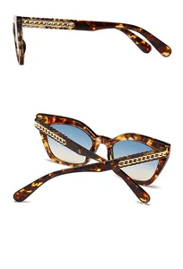 Détail de lunettes de soleil écailles avec chaîne dorée sur les branches modernes
