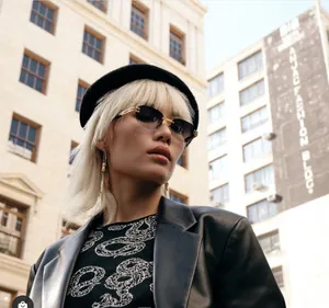 Close-up of retro square sunglasses with gradient lenses and gold frames in street style