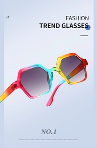 Close-up of hexagonal sunglasses featuring a vibrant rainbow gradient frame and grey lenses