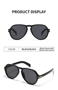 Detail of aviator sunglasses with black frame, grey lenses and gold metal arrow hinge