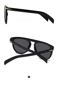 Macro detail of classic black oversized sunglasses with iconic gold arrow metal accents