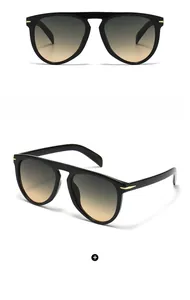 Detail of pilot sunglasses with black frame, green-yellow gradient lenses and gold metal trim