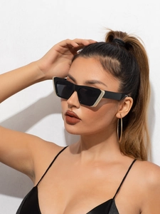 Close-up of cat-eye sunglasses with thick black frames and metal corner details